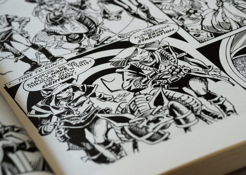 A close up of comic book pages with black and white drawings